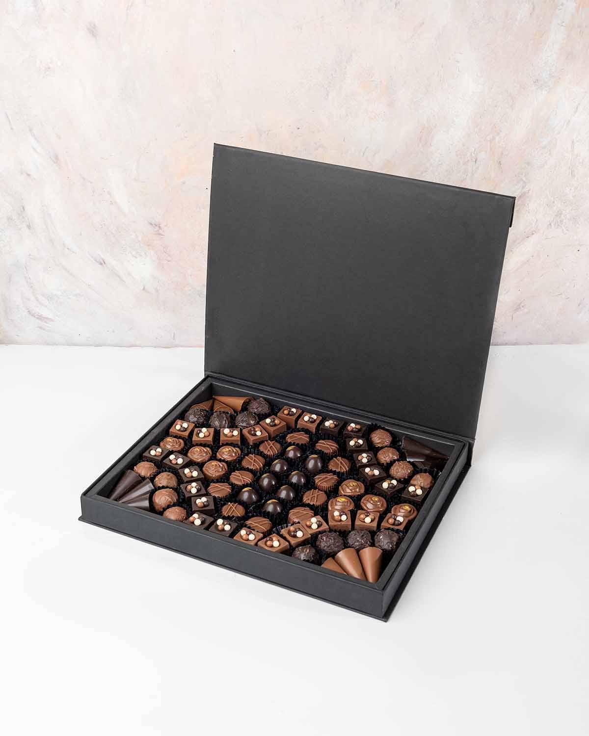 84 Assorted Chocolates by NJDChocolate & ConfectioneryYour Gift Contains:• 84 x Assorted Milk and Dark Chocolates • Flavors: Pistachio, Hazelnut, Speculoos, Peanut Butter, Roche, Cappuccino Cream, Dark Chocolate Cream, Raffaello, Salted Caramel• Chocolate